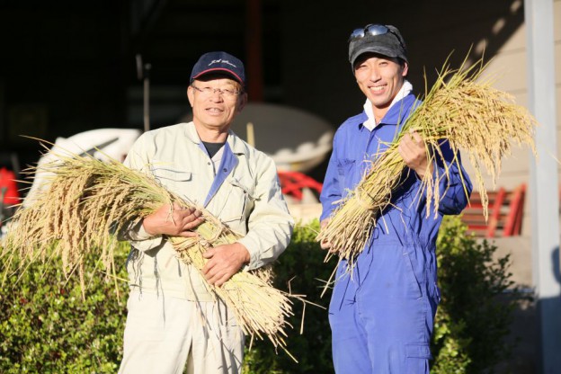 佐藤徹広さんと息子さん。収穫したお米と一緒に。